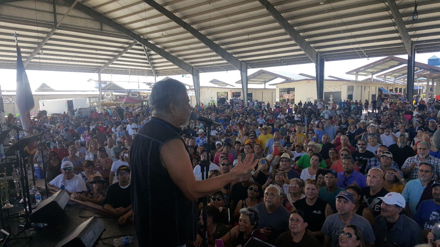 Large audience watching a Tejano musician address the crowd