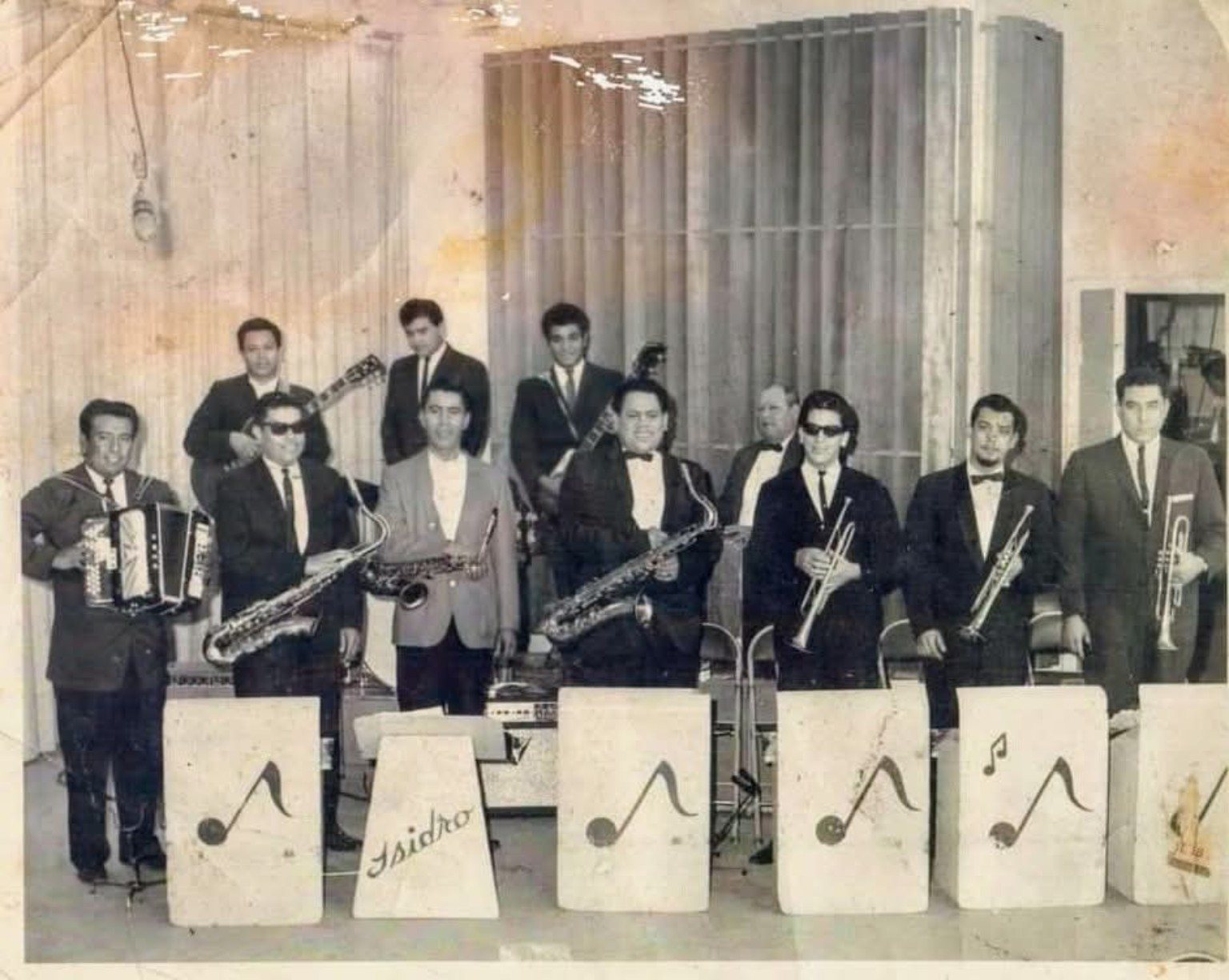 Historic Tejano orquesta posed behind bandstands