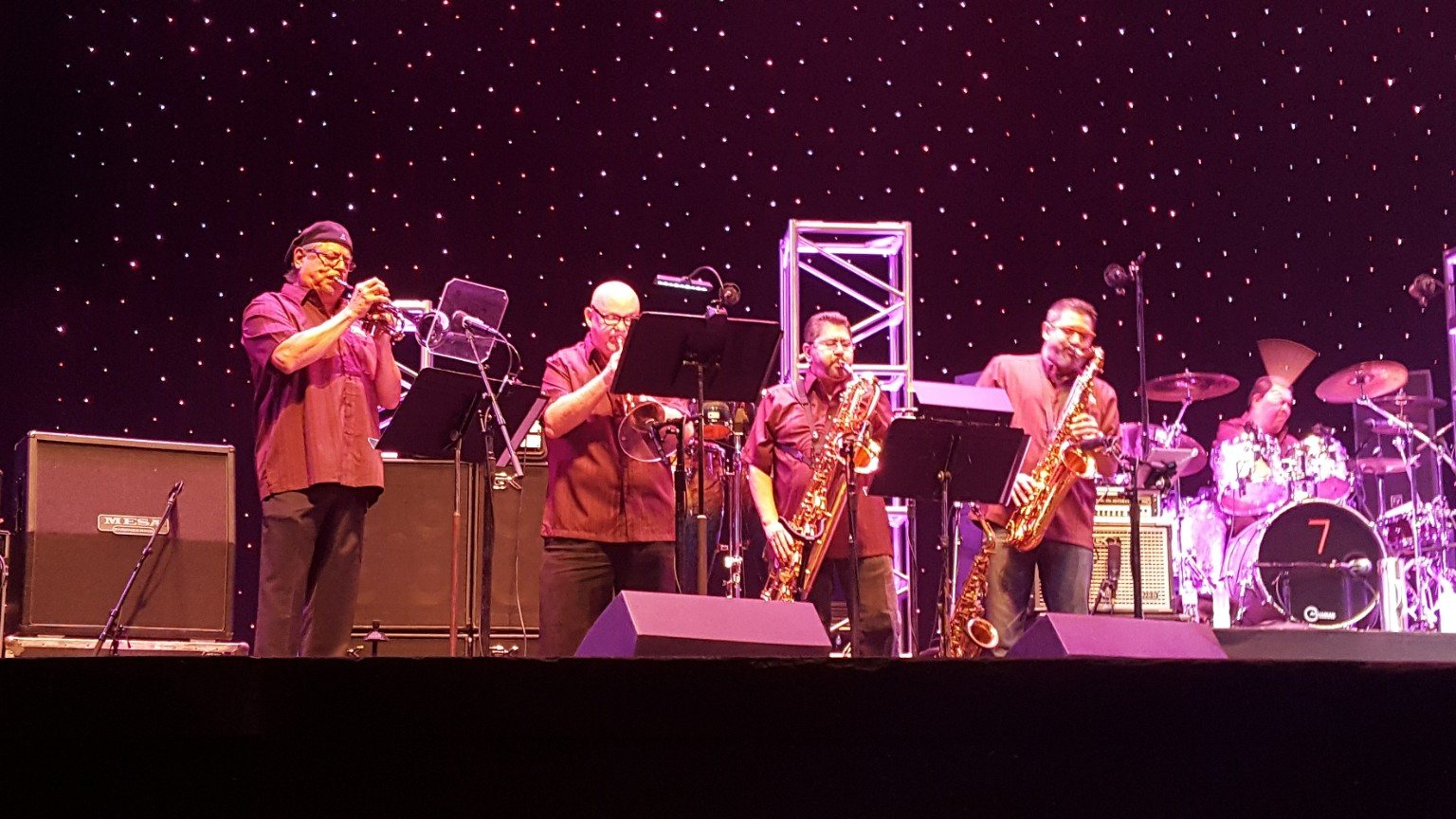 Modern horn-driven Tejano band performing under stage lights